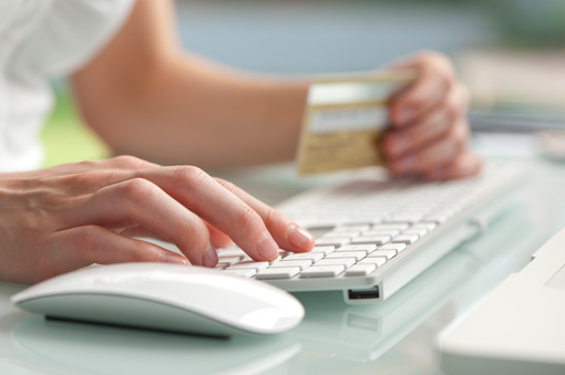 hands entering credit card information online