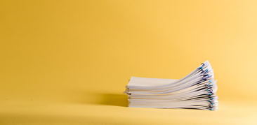 stack of papers on a yellow background